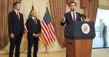 JD Vance speaks from a podium. Behind him are Steve Witkoff and Jared Kushner.