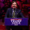 Tucker Carlson speaks from a Trump-Vance podium during 2024 campaign.