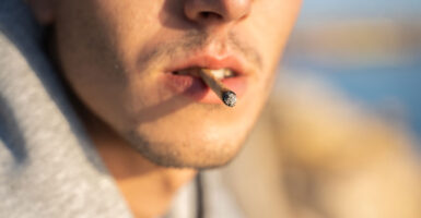 Extreme close-up of a male smoking a joint.
