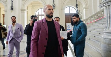 Andrew Tate walking with other men behind him