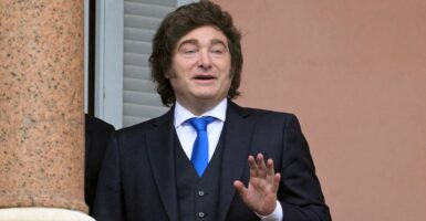 Argentina's President Javier Milei holding up his hand